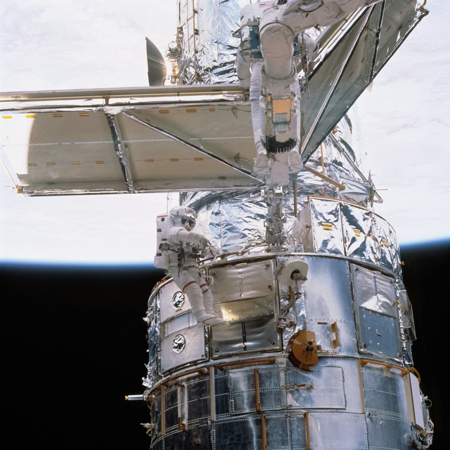 Astronauts performing maintenance on a spacecraft near Earth.