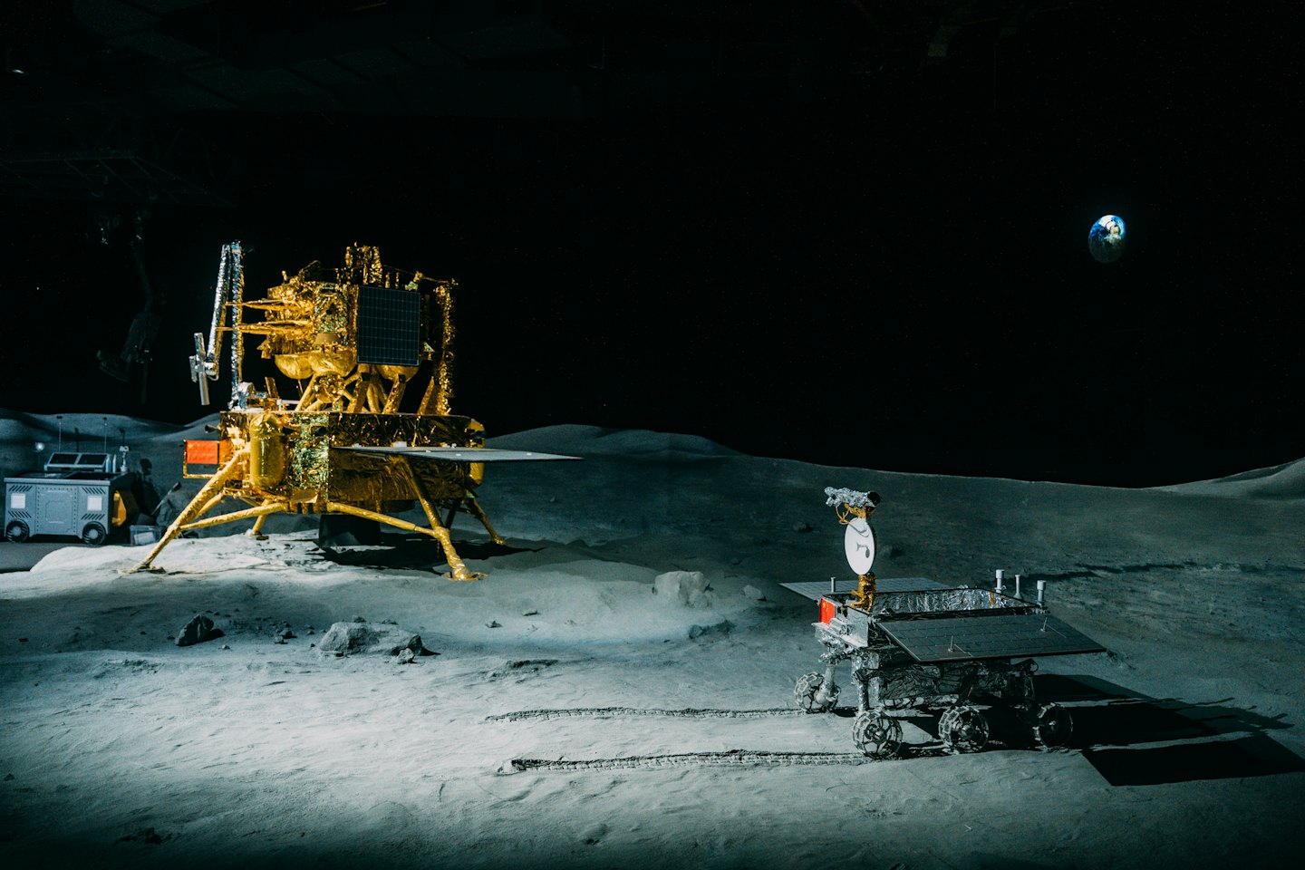 Lunar lander and rover sit on the dusty moon surface.